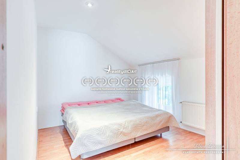 Bedroom in a family house with a large bed and a floor with a wood decor.