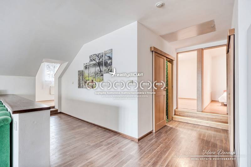 Interior of a family house with stairs, wooden floor decor, and a painting on the wall.