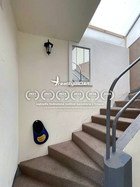 A staircase in a family house with white walls and a metal railing.