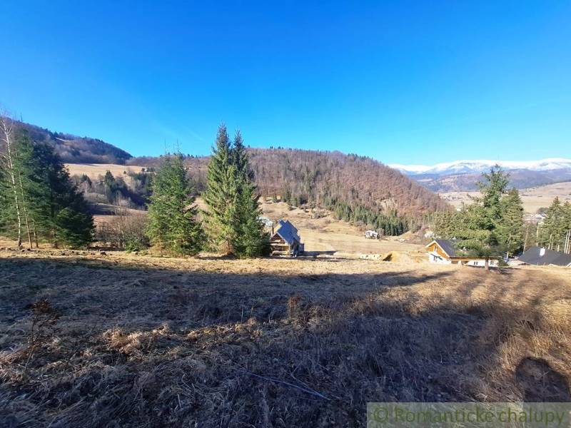 Agricultural and forest lands in Hronec, surrounded by hills and coniferous trees.