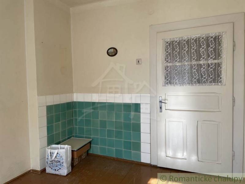 Interior of a family house with white doors and green and white tiles on the walls.
