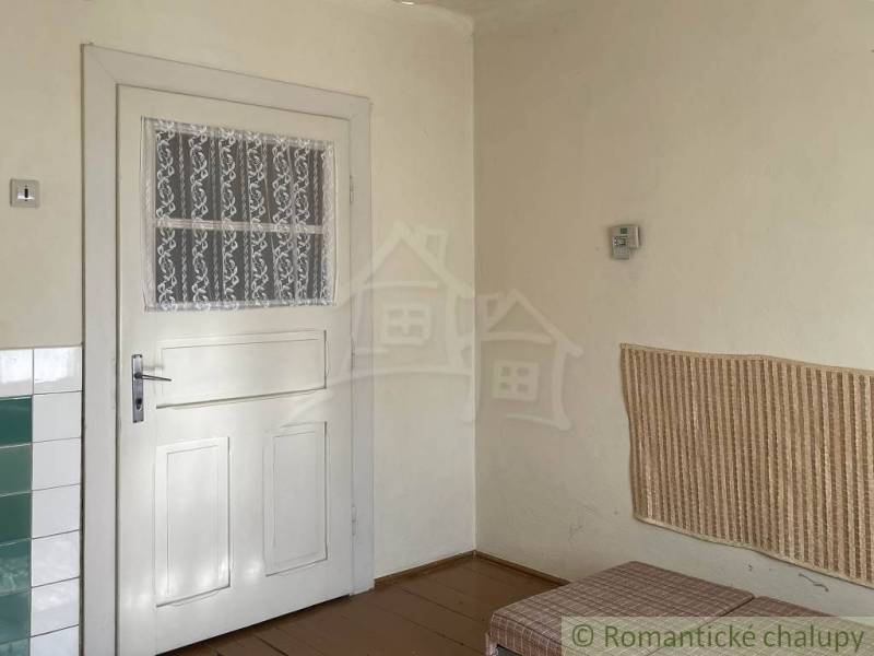 Interior of a family house with white doors, paneling, and flooring with a wooden decor.