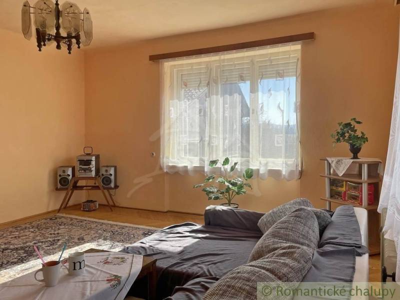 Living room in a family house with a sofa, carpets, and a hi-fi set.
