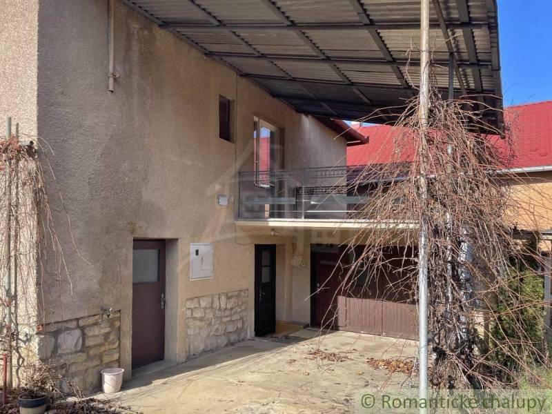 A family house in Bretka with a balcony, a garage, and a pergola for climbing plants.