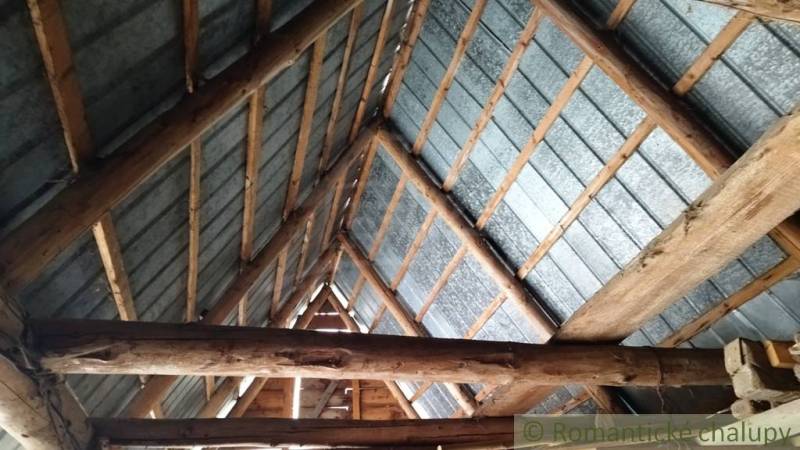 Roof structure of the interior in a family house with wooden beams and metal roofing.