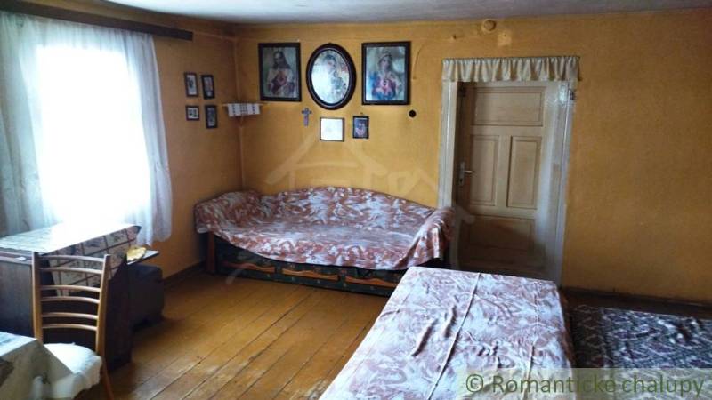 Interior of a family house with wooden flooring, tables, chairs, wall decorations.