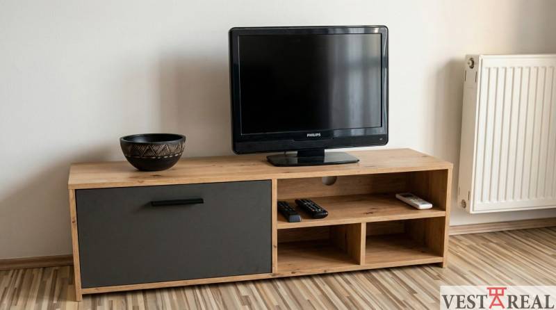 A television on wooden furniture with a wood-patterned floor in a studio apartment.