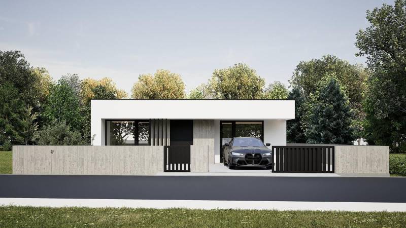 A family house in Nesvady with a concrete fence and a garage next to a green environment.