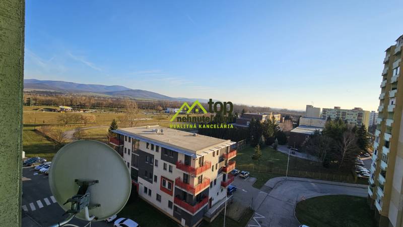View from a studio apartment in Topoľčany of the surroundings with apartment buildings and nature.