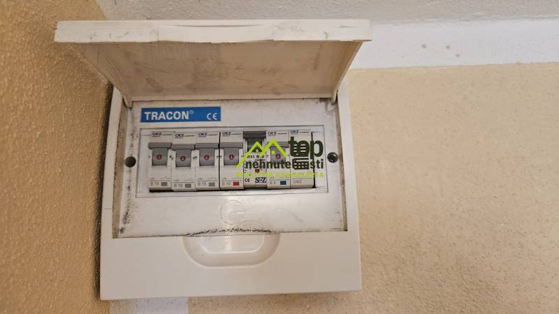 Electrical switchboard with circuit breakers in a studio apartment, mounted on the wall with a cover.