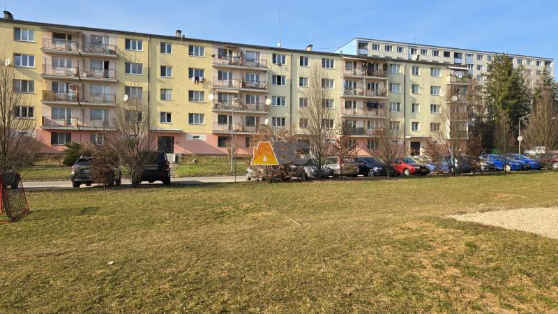 A block of flats on Prachatická Street in Zvolen, in front of which cars are parked.