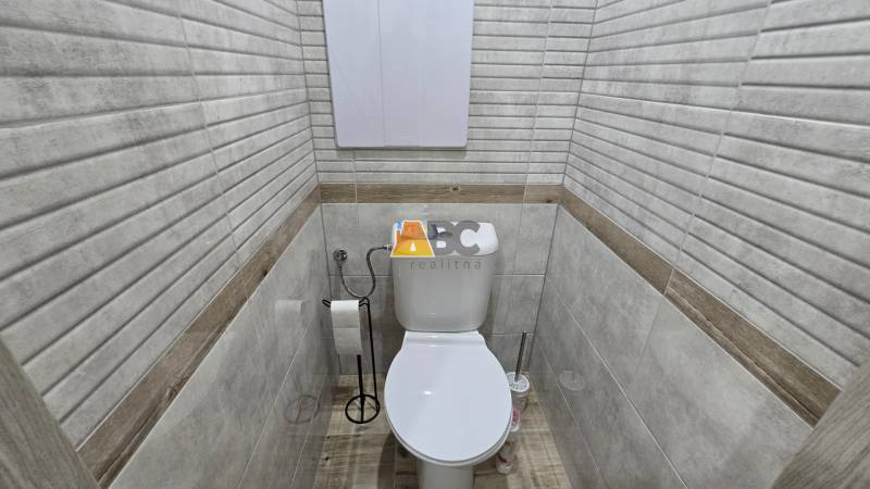 Bathroom from a 2-room apartment with a toilet and a floor with a wooden decor.
