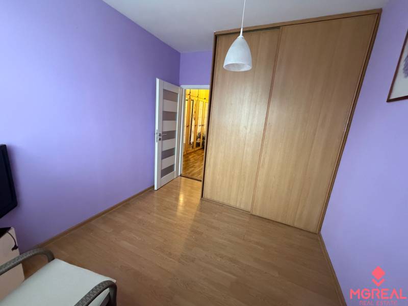 Purple walls, built-in wardrobe, and wooden decor flooring in a 3-room apartment.