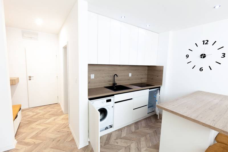 A modernly furnished kitchen with a wooden decor floor in a holiday apartment.