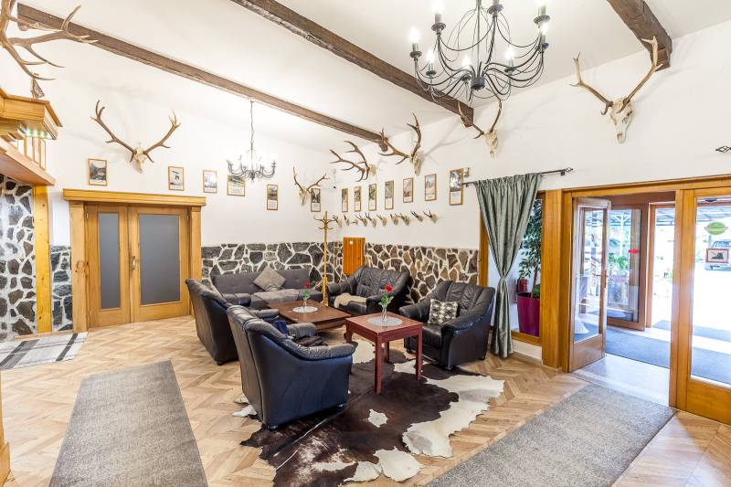 Interior of a holiday apartment with a leather sofa set, corners, and a floor with a wooden decor.