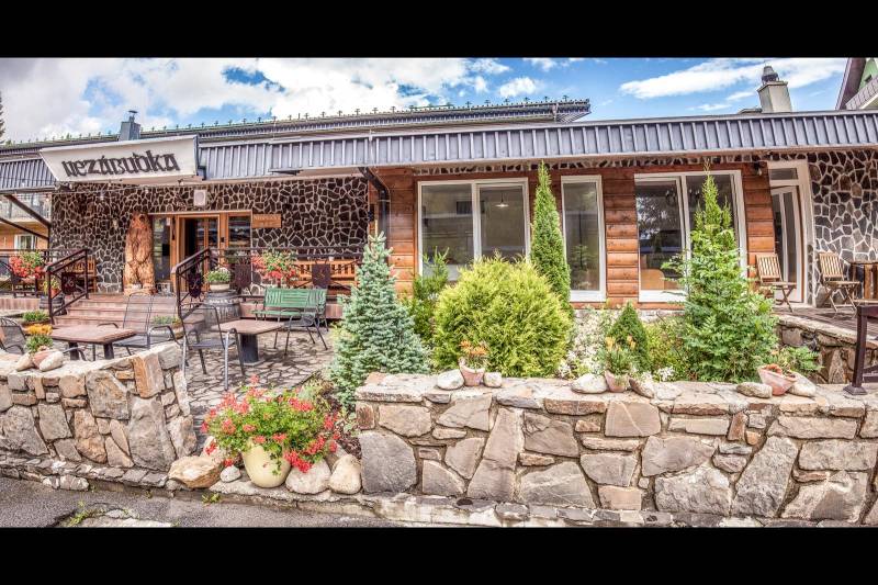 Stone facade of a Holiday Apartment in Štrba with a terrace and floral decoration.