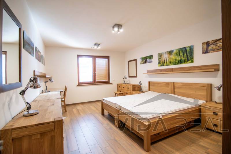 Bedroom with wooden furniture and a floor with a wood decor in a family house.