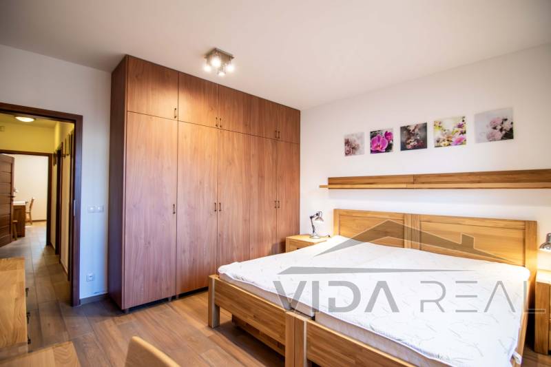 A bedroom with wooden furniture and a floor with a wooden decor in a family house.