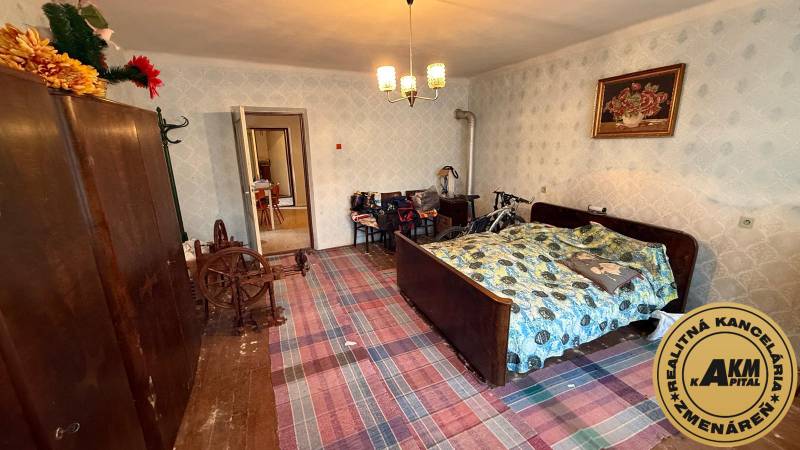 A room in a family house with a traditional bed, wardrobe, and bicycle.