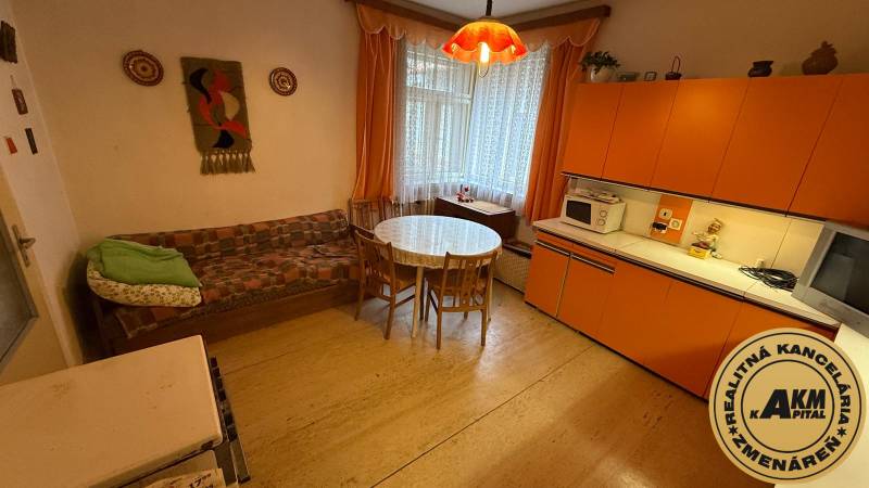 Interior of a family house with a retro kitchen, round table, and sofa.