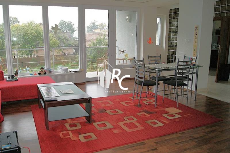 Living room in a family house with a wooden decor floor and a red carpet.