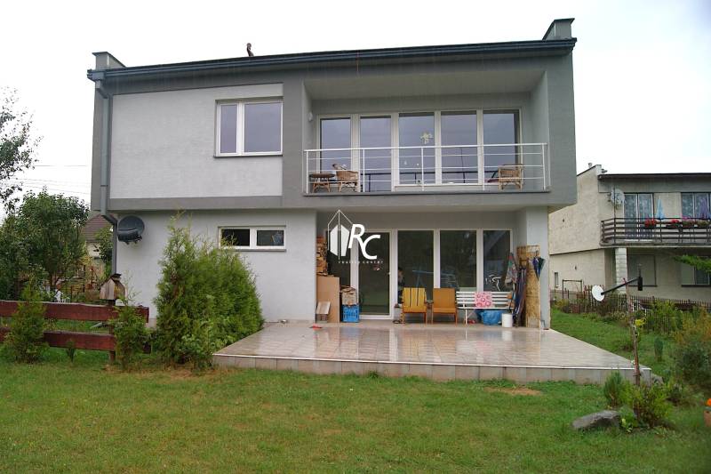 A family house in Bystrička, a terrace with seating, large windows, and a manicured lawn.