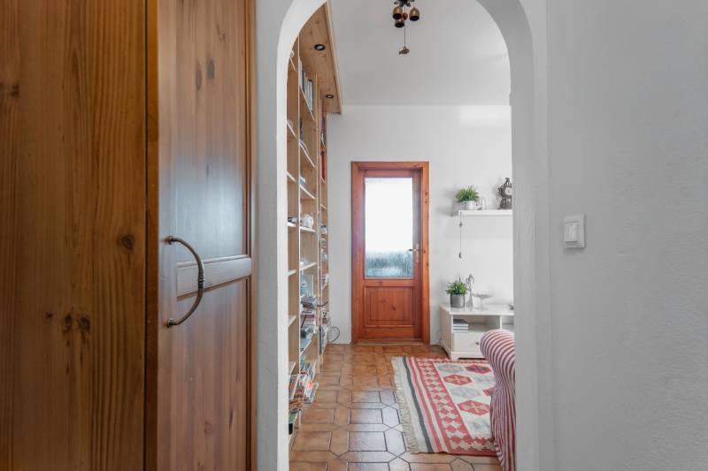 Living room of a 4-room apartment with a patterned carpet, a swinging chandelier, and wooden doors.