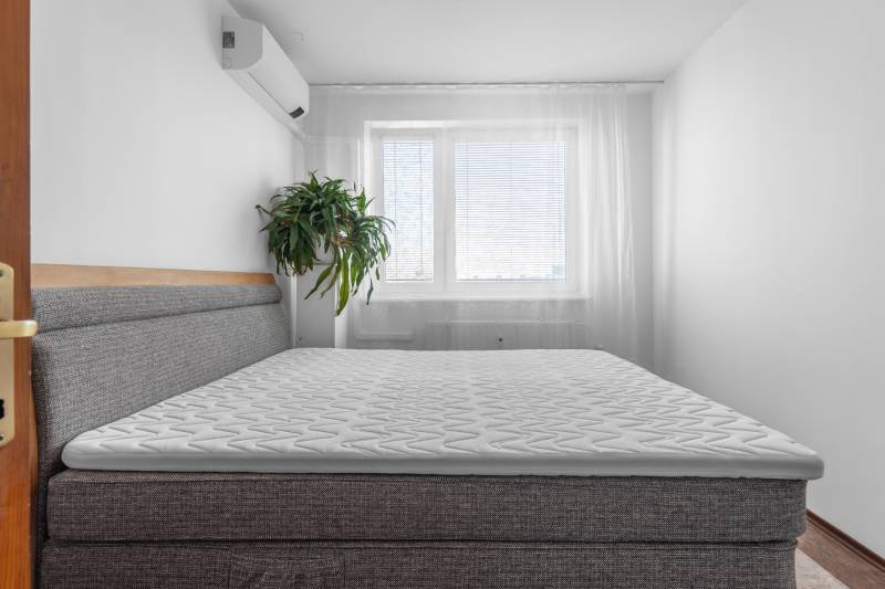 A bedroom with air conditioning and a bed in a 4-room apartment.