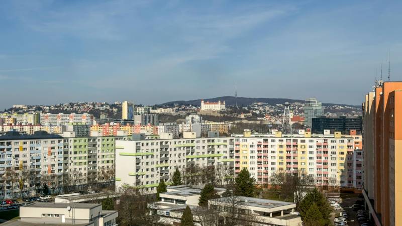 View of apartment buildings in Bratislava - Petržalka on Ševčenkova Street, with Bratislava Castle in the distance.