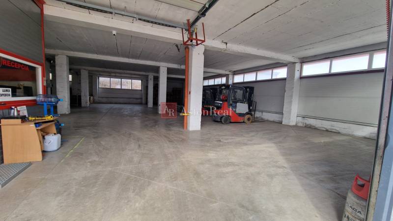 Interior of warehouses and halls with high ceilings and work equipment, including a forklift.