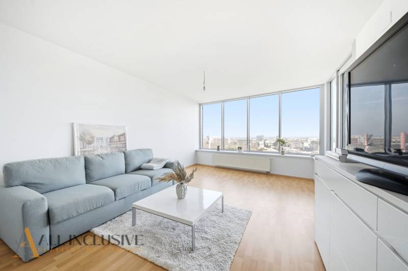 Living room with wood-patterned flooring, large windows, and a comfortable sofa in a two-room apartment.