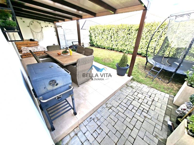 The garden of a family house on Mládežnícka Street in Galanta: terrace, trampoline, grill, seating area.