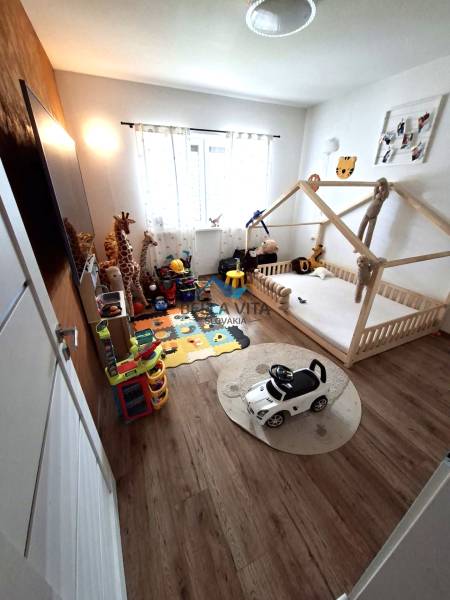 Children's room in a family house with a crib, toys, and a floor with a wooden decor.
