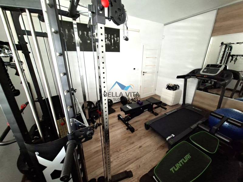 Home fitness in a family house with a wooden decor floor, gym and treadmill.