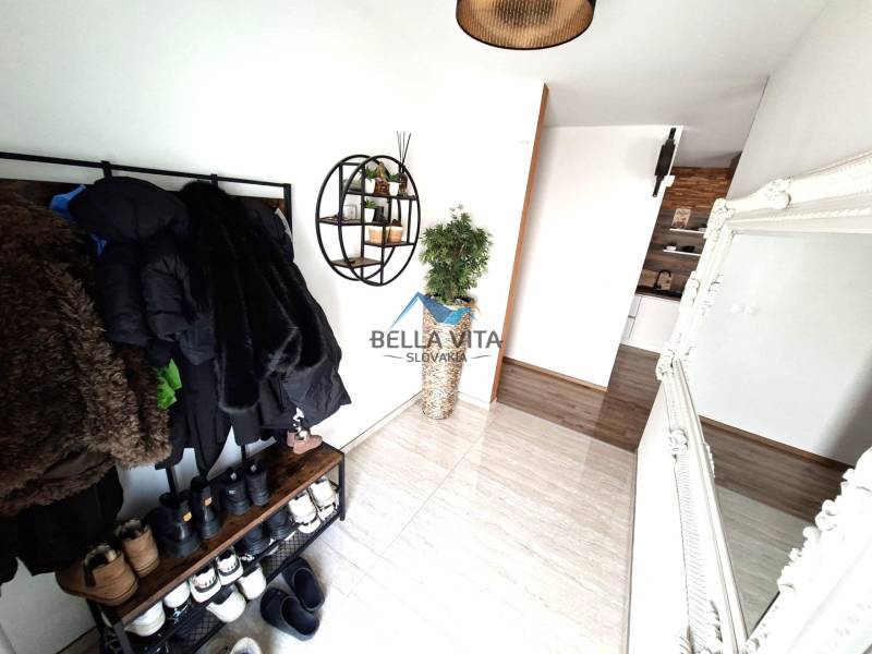 Interior of a family house with a coat rack, mirror, and wooden decor flooring.