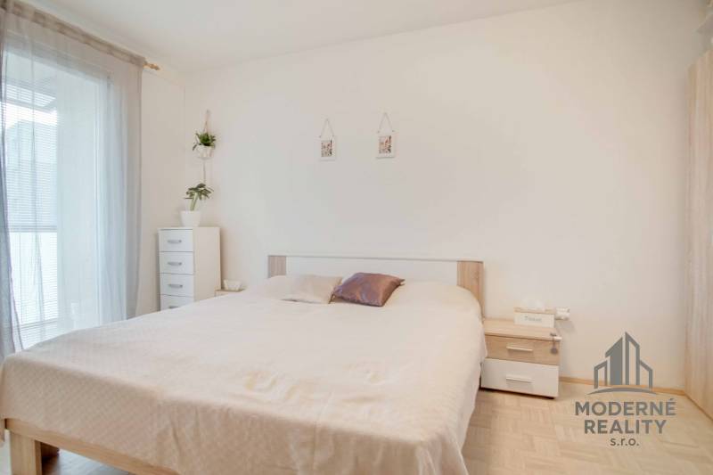 A bright bedroom with a built-in wardrobe and decorative elements in a 3-room apartment.