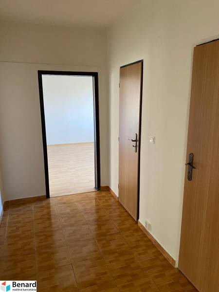 Interior of a 3-room apartment with a wooden decor floor and white walls.