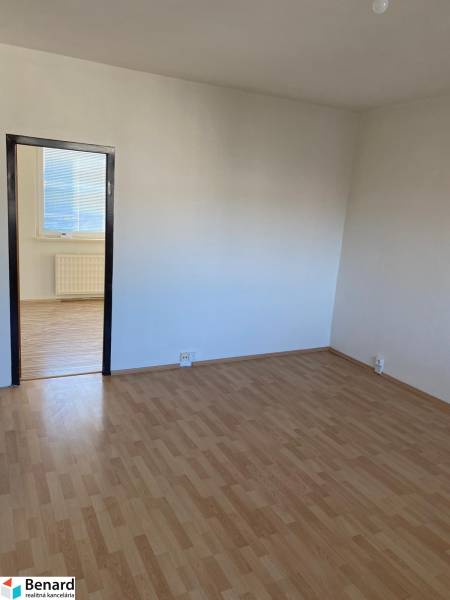 A room in a 3-room apartment with white walls and a wooden decor floor.