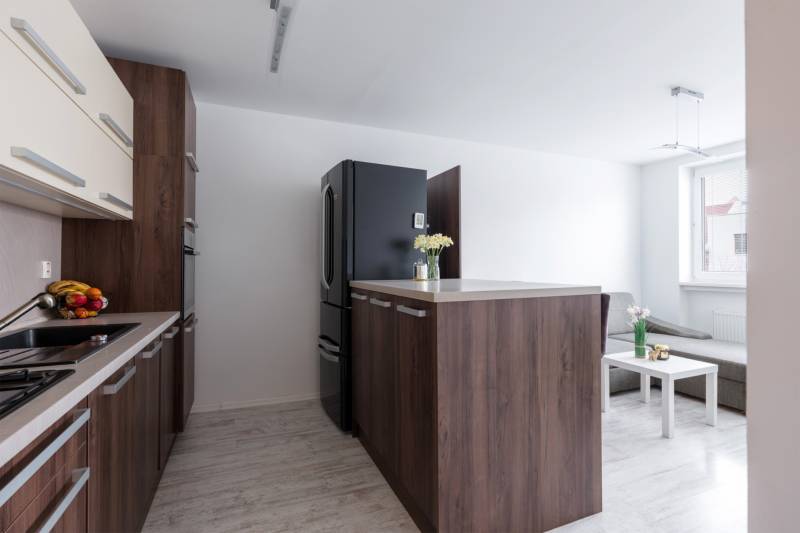 A kitchen in a 2-room apartment with a kitchen unit and a floor with a wooden decor.
