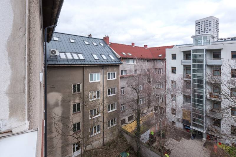 A view of apartment buildings and a courtyard in Bratislava - Ružinov with leafless trees.