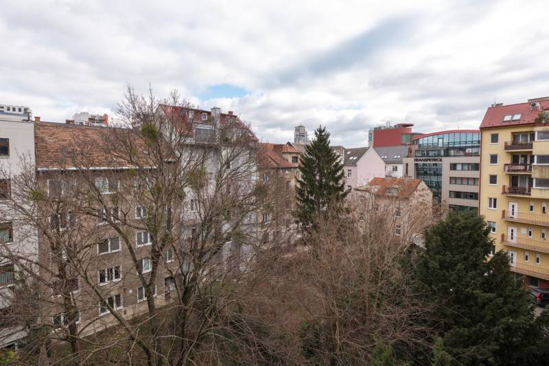View of residential buildings and trees in Bratislava - Ružinov, ideal for a 2-room apartment.