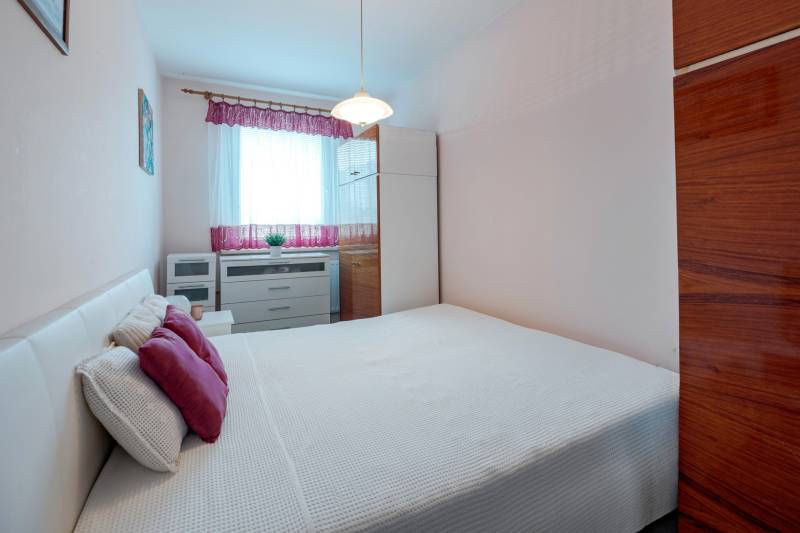 Bedroom with white bed linen and cabinets, 4-room apartment.