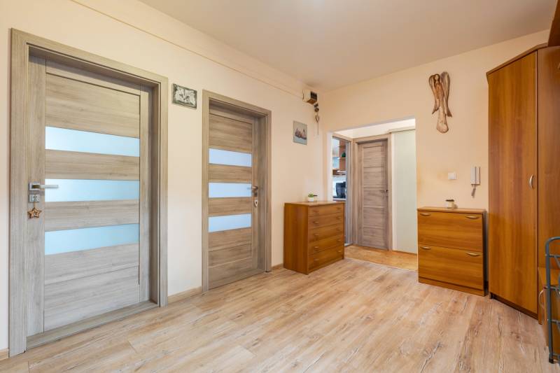 A hallway with wardrobes and dressers in a 4-room apartment, floor with wood decor.