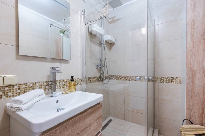 Bathroom in a 4-room apartment with a walk-in shower and a pedestal sink.