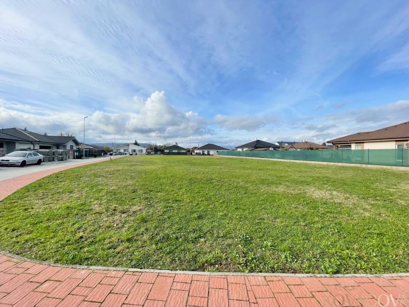 A view of a spacious building plot in Kočovce, surrounded by family houses.