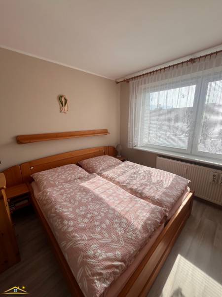 A bedroom in a 3-room apartment with wooden furniture and a floor with a wooden decor.