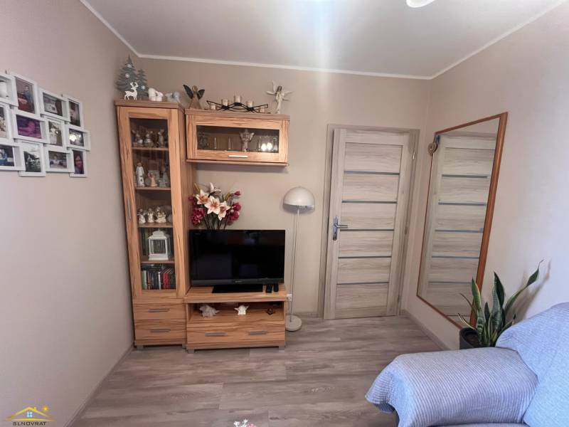 A room with a television, a mirror, a wooden set, and a sofa, in a 3-room apartment.