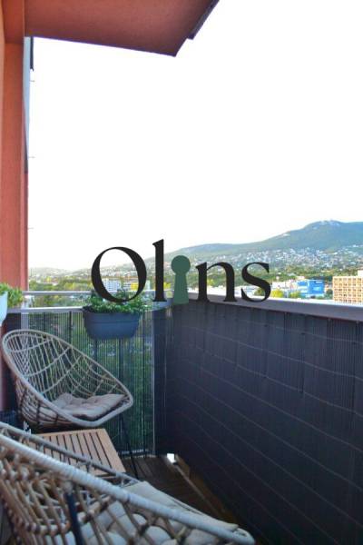 A balcony with rattan chairs and a view of greenery in a 3-room apartment.