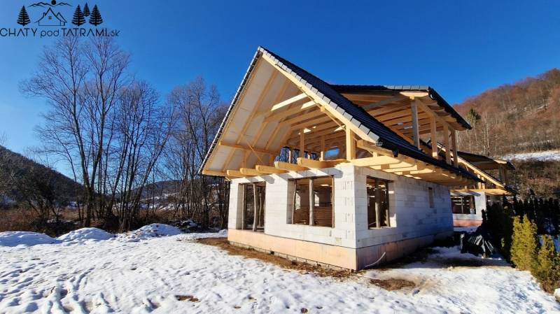 An unfinished cottage with a wooden roof during winter in Mýto pod Ďumbierom.