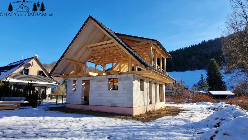 A cabin construction in Mýto pod Ďumbierom in a winter landscape with a wooden structure.